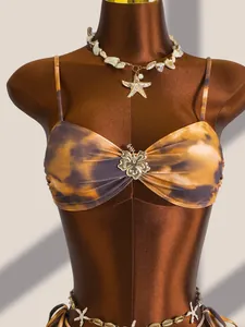 Detailopname van Maillard tie-dye bikinitop met schelpenaccessoires op een paspop