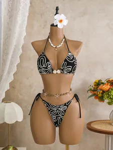 Close-up detail of black crinkle bikini with white swirl pattern on resort mannequin