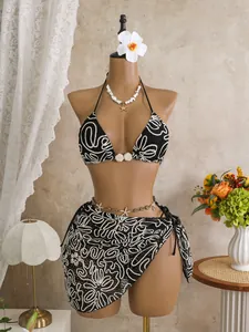 Detailed view of sexy three-piece bikini set with abstract swirl print on mannequin