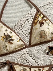 Detalle del bordado de flores con lentejuelas doradas en un top de bikini beige