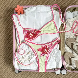 Retro-Bikini-Set mit Blumenmuster und rosa Muschelsaum in einem rosa Reisekoffer