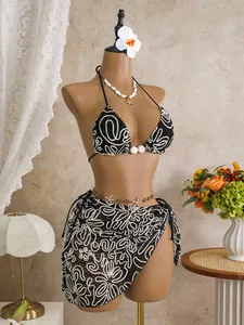 Elegant black and white printed 3-piece bikini set displayed on a mannequin in a room
