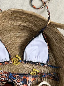 Gros plan d'un bikini léopard avec des détails élégants en métal doré en spirale.