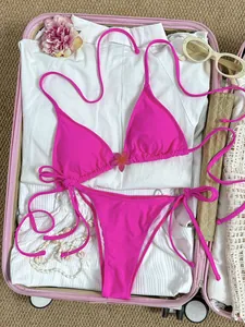 Detailopname van een levendige roze bloemen bikini set in een reiskoffer voor vakantie