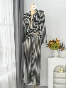 Elegant black and white striped four-piece beachwear set with long sleeves and wide pants