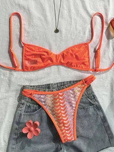 Detailansicht eines böhmischen Häkel-Bikinis in Orange mit Jeans-Shorts und Accessoires