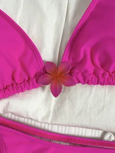 Close-up van roze halter bikini top met verloop bloemdetail en verzamelde stoftextuur
