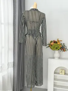 Back view of a black and white striped long sleeve beach cover-up set on mannequin.
