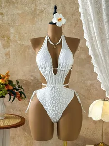 Detailed view of white leopard print cutout one-piece swimsuit on professional mannequin