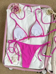 Sexy felroze driehoekige bikini-set met vlinderdetail in een roze reiskoffer