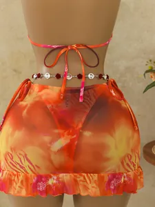 Achteraanzicht van bohemien driedelig bikiniset met oranje print en mesh rokje.