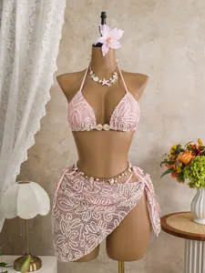 Detailed view of a stylish pink lace three-piece bikini set with a matching beach sarong.