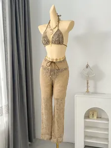 Detail view of leaf pattern lace trousers and bikini set on mannequin