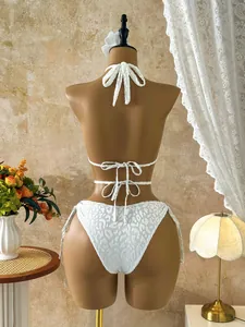 Back view of a sexy white leopard print lace-up bikini set shown on a professional mannequin