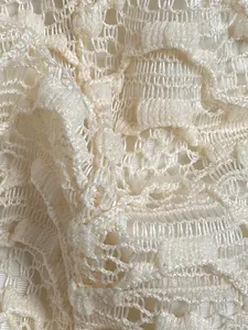 Gedetailleerde macro-opname van de delicate crèmekleurige kanttextuur van een bikini.
