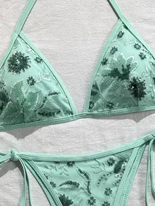 Primer plano del bordado de lentejuelas florales verde menta en el bikini
