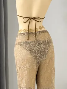 Back view of sheer leaf-patterned mesh pants and brown bikini top on a mannequin