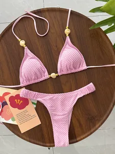 Textured pink bikini set with beaded details and halter neck for women's beachwear