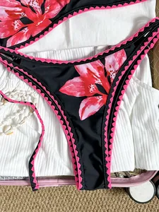 Detailansicht der Bikinihose mit Blumenmuster und pinkfarbenem Häkel-Stickereirand.