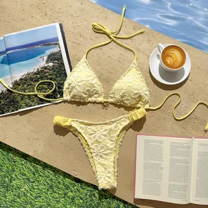 Vista detallada del bordado de encaje floral amarillo en un bikini sexy junto a la piscina