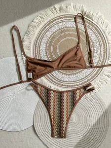 Detalle de bikini boho de ganchillo con zigzag y top marrón sobre alfombras.
