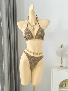 Detailed view of a beige crochet triangle bikini set featuring palm leaf patterns on a mannequin