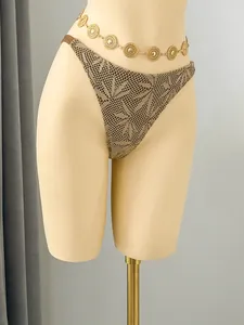 Detail of beige crochet bikini bottom featuring elegant leaf pattern on display mannequin