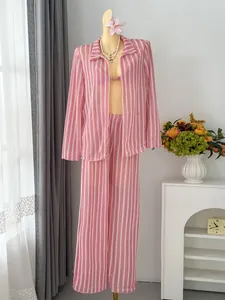 Close-up detail of the pink striped four-piece beach cover-up and bikini set on a mannequin