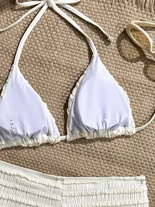 Détail d'un haut de bikini blanc froncé montrant la doublure et le tissu texturé