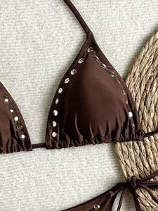Detailed view of a brown halter bikini top with metallic silver studs and tie straps.