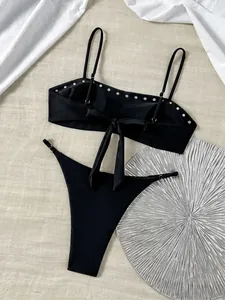 Gedetailleerde weergave van zwarte bandeau bikini met zilveren studs en striksluiting