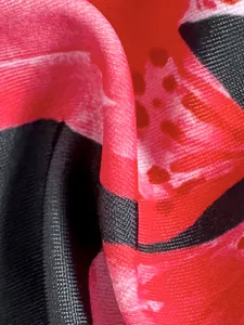 Hochauflösendes Makrodetail der Badeanzug-Stoffstruktur mit rot-schwarzem Blumendruck