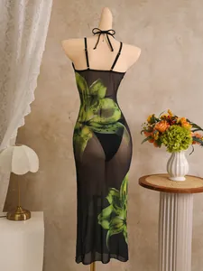 Achteraanzicht van een transparante zwarte mesh strandjurk met groene bloemenprints.