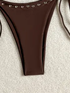 Close-up detail of dark brown bikini bottom with silver metal rivet studs decoration