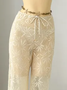 Detail view of cream crochet pants featuring leaf pattern for elegant beach cover-up