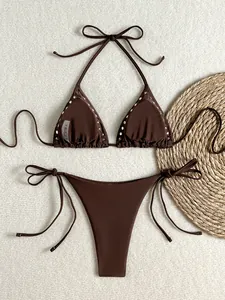 Detail of dark brown bikini top featuring decorative silver metal studs and halter ties
