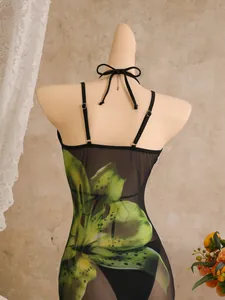 Gedetailleerd achteraanzicht van een zwarte mesh swimsuit cover-up met lelieprint