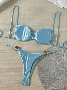 Detailansicht hellblauer glänzender Bikini mit metallischen Beschlägen