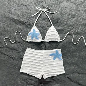 Détail d'un ensemble bikini froncé blanc avec appliques d'étoiles de mer bleu brillant