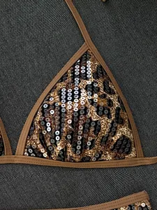 Dettaglio delle paillettes luccicanti e della stampa leopardata sul top del bikini