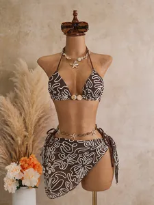 Detail view of a 3-piece brown bikini set featuring white abstract embroidery pattern.