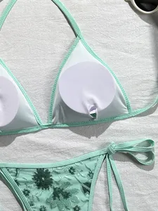 Primer plano de bikini verde menta con bordado de lentejuelas y relleno extraíble.