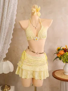 Detaillierte Ansicht des gelben Bikini-Sets mit Blumenstickerei und Strandrock