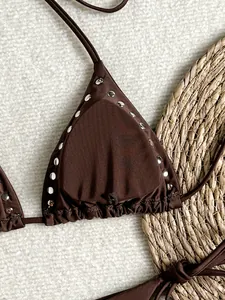 Macro view of a brown triangle bikini top featuring decorative silver metal stud accents