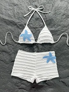 Ensemble bikini deux pièces blanc avec appliques d'étoiles de mer bleues et froufrous