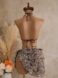 Back view of sexy brown three-piece bikini set with floral mesh cover-up on mannequin