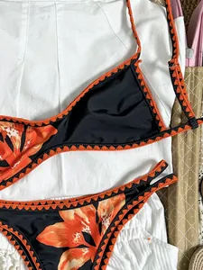 Detailansicht des Retro-Bikinis mit lebhaftem Blumenmuster und orangefarbenem Häkelbesatz