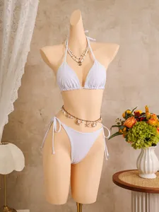 Elegant wit bikini-setje op paspop met strand-thema accessoires