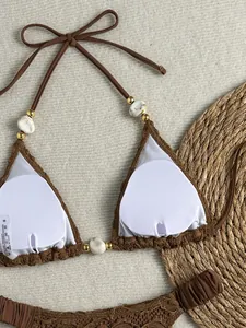 Detail van bruine getextureerde bikinitop met marmeren kralen en witte binnencups