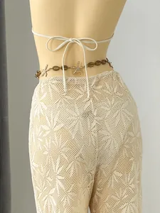 Detailed back view of beige leaf pattern lace beach trousers with starfish waist chain